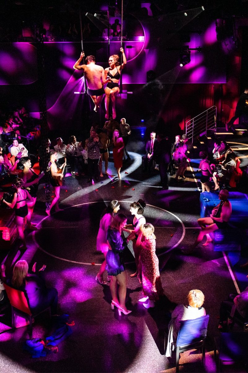 Aerialists perform above dancers and guests during a show aboard a Virgin Voyages ship.